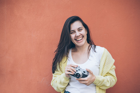 young pretty woman taking picture with old cameraの写真素材