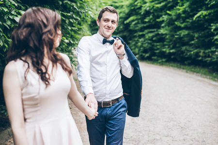 man and woman walking in park in elegnance dressの写真素材