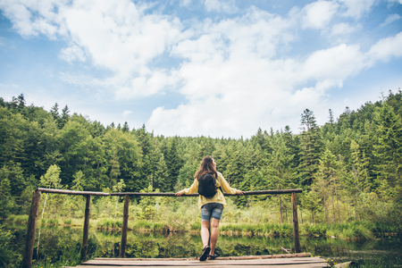 woman looks at lake in Carpathian mountainsの写真素材
