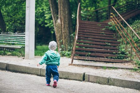 1 year old baby walking by parkの写真素材