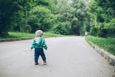 1 year old baby walking by parkの写真素材