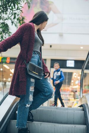 young woman on escalator in mallの写真素材