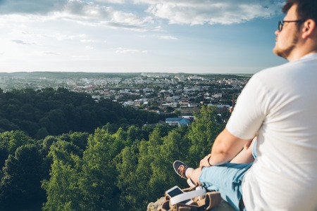 man sitting on the peak with phoneの写真素材