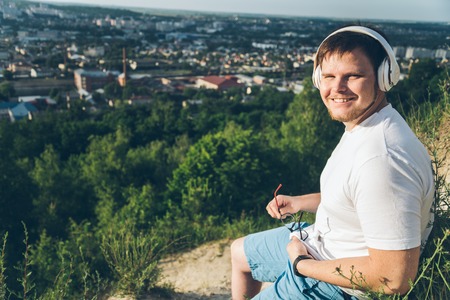 man listen music on the peak of the hill