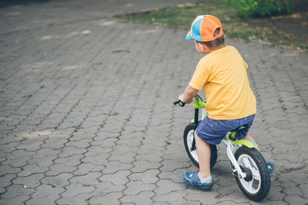 young boy riding strider bikeの写真素材