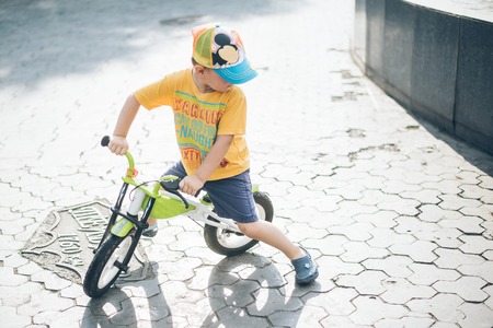 young boy riding strider bike