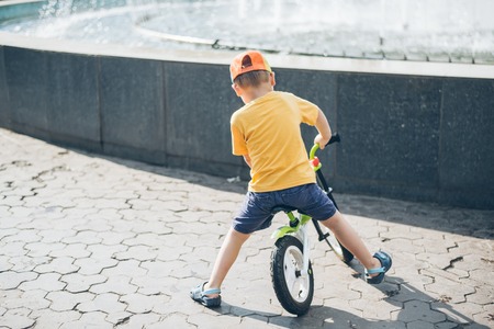 young boy riding strider bike