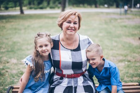 Grandmother playing in the park with grandchildrenの写真素材