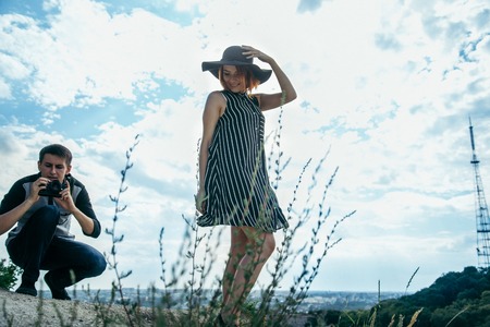 young couple on the hill, man taking picture of his girlfriendの写真素材