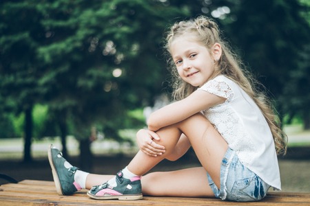 Cute little blond girl in summer clothes outdoorの写真素材