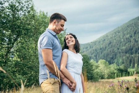 couple in love walking in feild with beautiful view on moutainsの写真素材