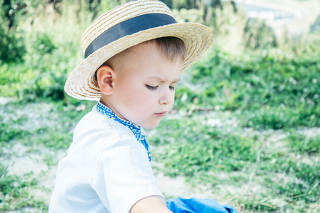 little boy sitting on the ground on the top of the mountainsの写真素材