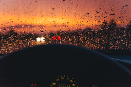 Rain drop on the car glass background with red sunsetの写真素材