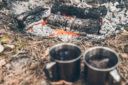 two metal cups with tea near bonfireの写真素材