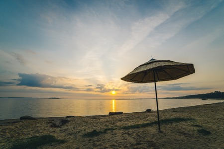 beach umbrellu on the seaside with sunrise on backgroundの写真素材