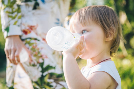baby drinking water from baby bottleの写真素材