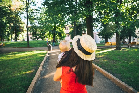 woman walk by park with baby in her armsの写真素材
