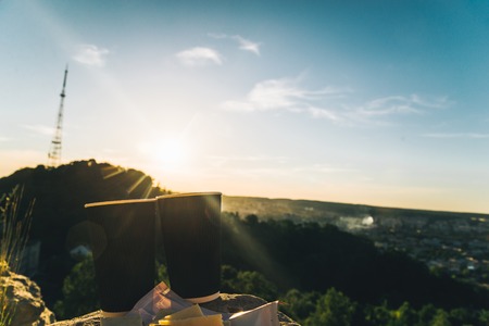 two cups of coffee on the peak of the hill