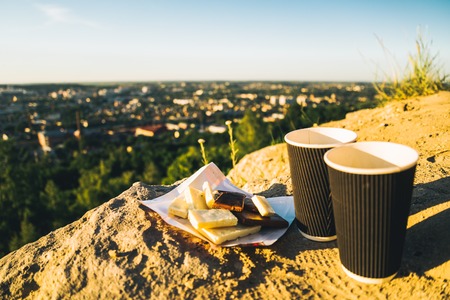 two cups of coffee on the peak of the hill