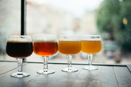 four glasses of beer on wooden tableの写真素材