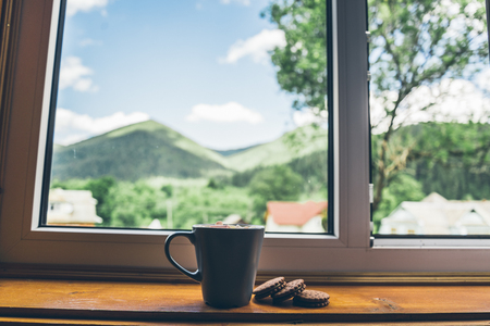 cup of coffee with cookies on windowsillの写真素材