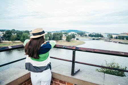 woman standing on the pier in the city and looking on the riverの写真素材