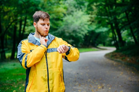 man measuring his pulse while runningの写真素材
