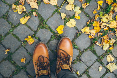 man boots top view with yellow leavesの写真素材