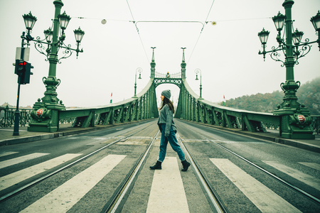 young pretty woamn walking cross the road in old european cityの写真素材