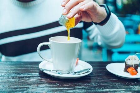 mans hand add honey to his teaの写真素材