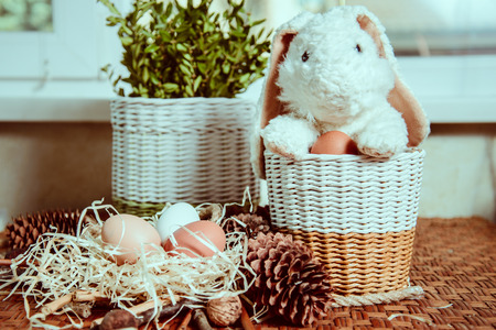black fluffy bunny near basket with eggsの写真素材