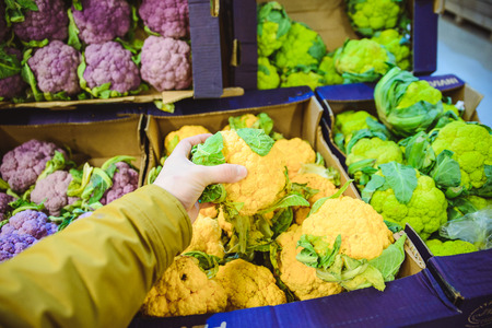 first person view man take cauliflower on the marketの写真素材