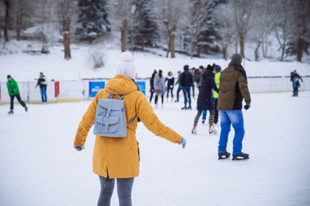 young woman learn to ski at city ice rink