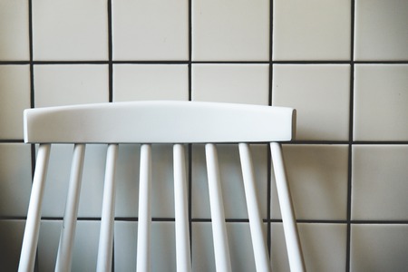 empty white stool in front of white tile