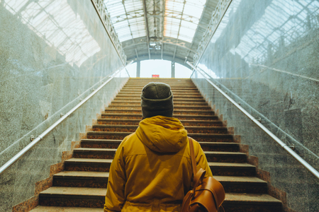 woman climb stairs with bags at railway station travel conceptの写真素材