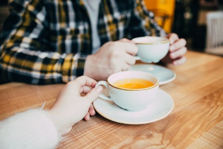 couple sit in cafe and drink orange tea