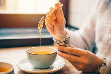 woman drink hot orange tea in cafeの写真素材