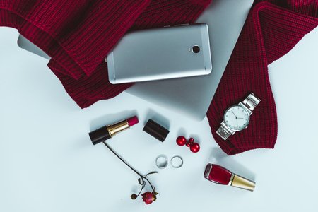 flat lay red sweater with different stuff on white backgroundの写真素材