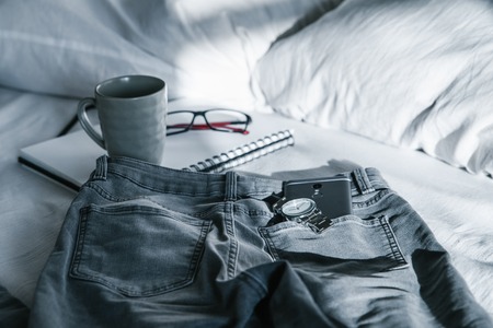 morning concept cup notebook jeans on the bedの写真素材