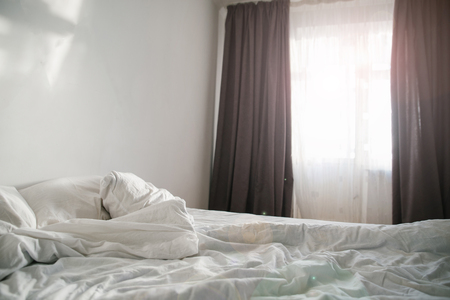 morning concept sunlight from the window on empty bedの写真素材