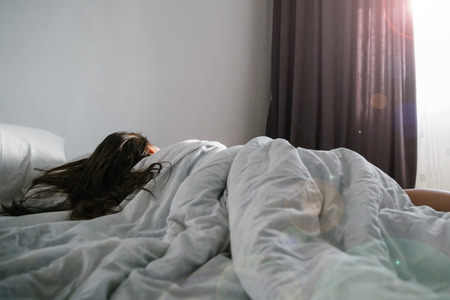 woman sleep in bed sunshine thought the windowの写真素材