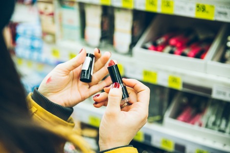 woman choose lipstick in store close up
