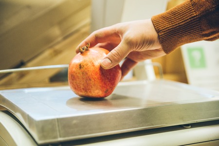 man weigh garnet on digital scales. shopping conceptの写真素材