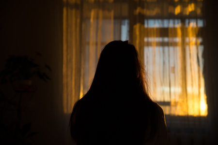 woman silhouette in front of window. sunrise in window. Wake up in morningの写真素材