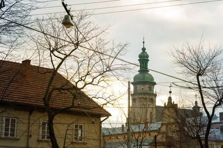 old church tower in front of tree without leaves. autumn season.の写真素材