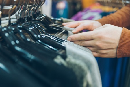 man hands close up looking for clothes in store. shopping conceptの写真素材