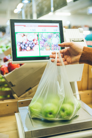 man weigh fruits on digital scales. shopping conceptの写真素材