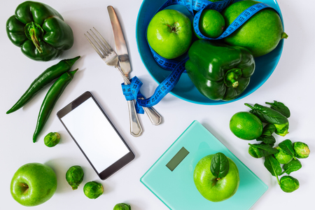 healthy food concept. green food on white background. mobile phone with white screen.の写真素材