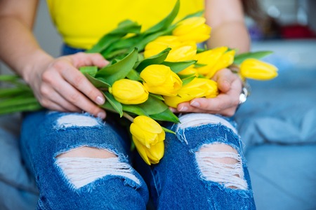 woman hold bouquet of yellow tulips. romantic flowers kneesの写真素材