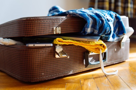 overloaded suitcase with clothes. travel concept. bag with garmentの写真素材